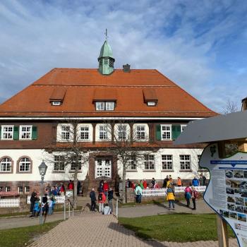 Das markante Schulhaus auf dem Dobel wurde 1914 gebaut - direkt davor steht eine der Hinweistafeln, die wissenswertes zum Kurbetrieb der Gemeinde aufzeigt - (c) Sabine Zoller